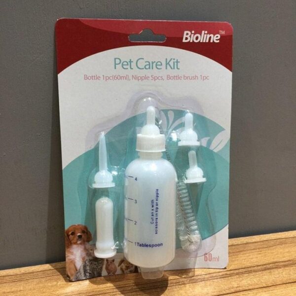 Close-up of a packaged Bioline Pet Care Kit. The kit includes a clear plastic 60ml feeding bottle with volume markings, five assorted feeding nipples (two attached to the bottle and three separate), and a bottle cleaning brush. The packaging is red and teal, with the brand name "Bioline" at the top and the product description "Pet Care Kit" with contents listed: "Bottle 1pc (60ml), Nipple 5pcs, Bottle brush 1pc." A small graphic on the bottom left shows a puppy, a kitten, and other small animals.