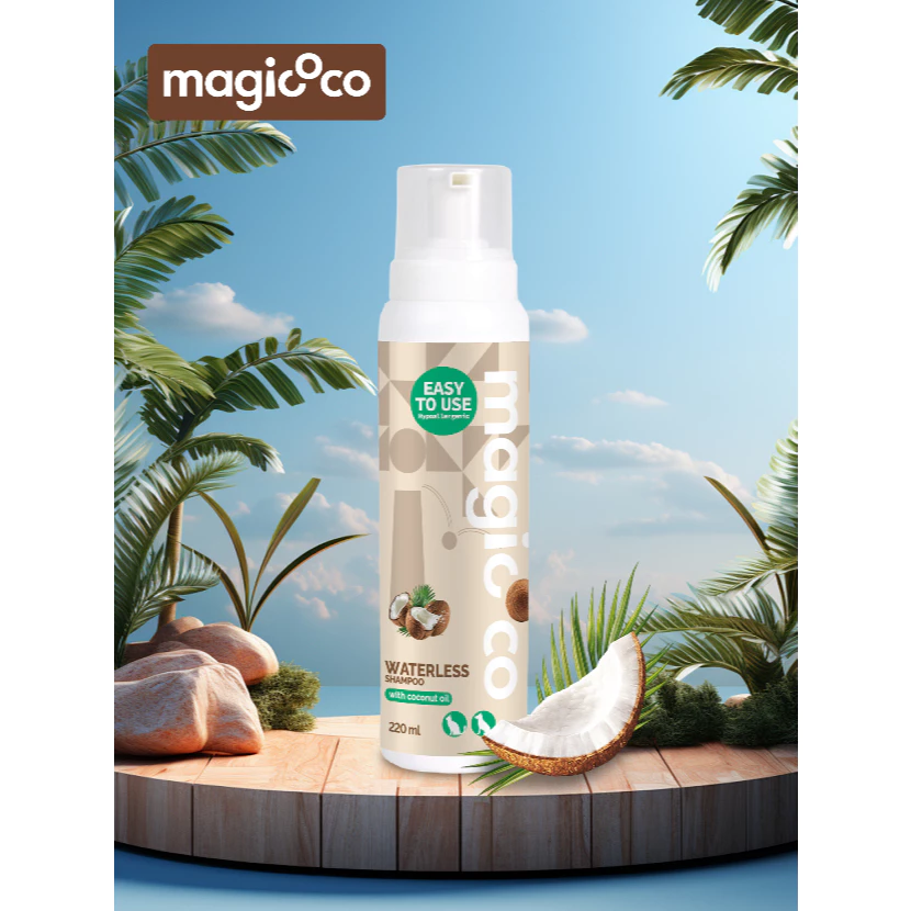 Product image of the magicoco Waterless Shampoo foam bottle (220 ml) set on a wooden deck in a simulated tropical environment with palm trees and a bright blue sky, emphasizing the coconut oil ingredient.