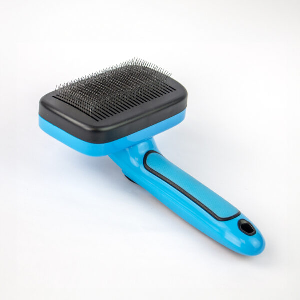 Slick Dog Brush Self Cleaning, a blue and black dog brush with a black, rectangular base of metal bristles and a blue handle with a black textured grip.