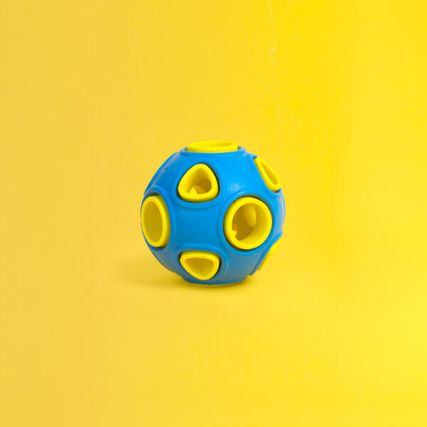Whirlball Rubber Dog Toy, a spherical blue and yellow ball with many holes and cutouts on its surface.
