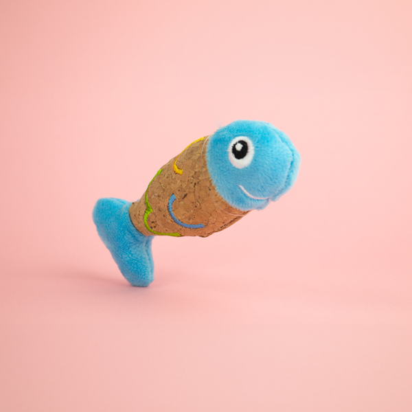 Zugo Fish Plush Catnip Toy, a plush toy shaped like a fish that has a light brown body with a pattern of green and yellow lines and a light blue plush head and tail.