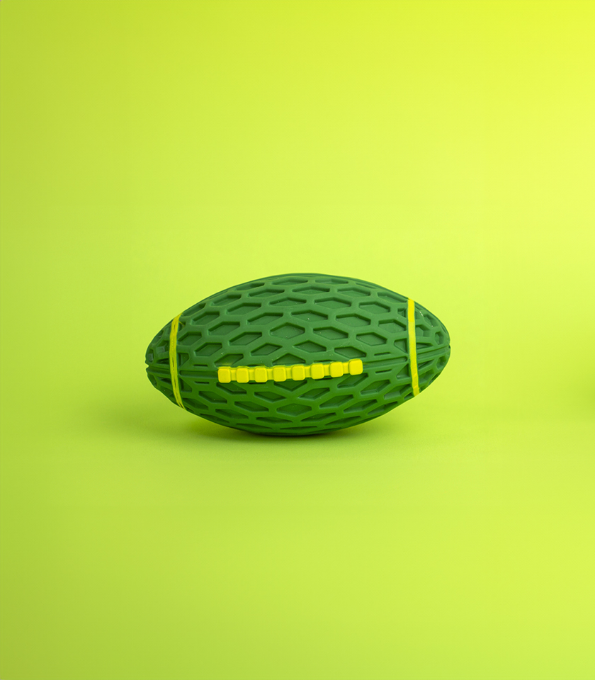 Rugby Ball Rubber Dog Toy, a green, rugby ball-shaped toy with a honeycomb texture and bright yellow bands.