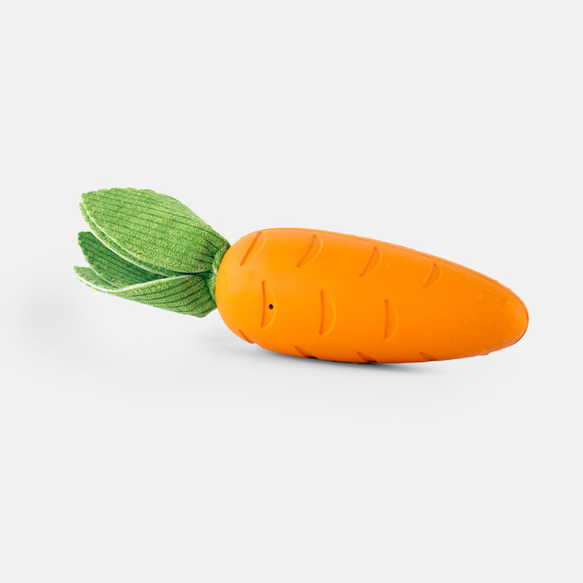 Crisp Carrot Rubber Dog Toy, a realistic carrot-shaped toy with a bumpy orange body and three fuzzy green leaves.