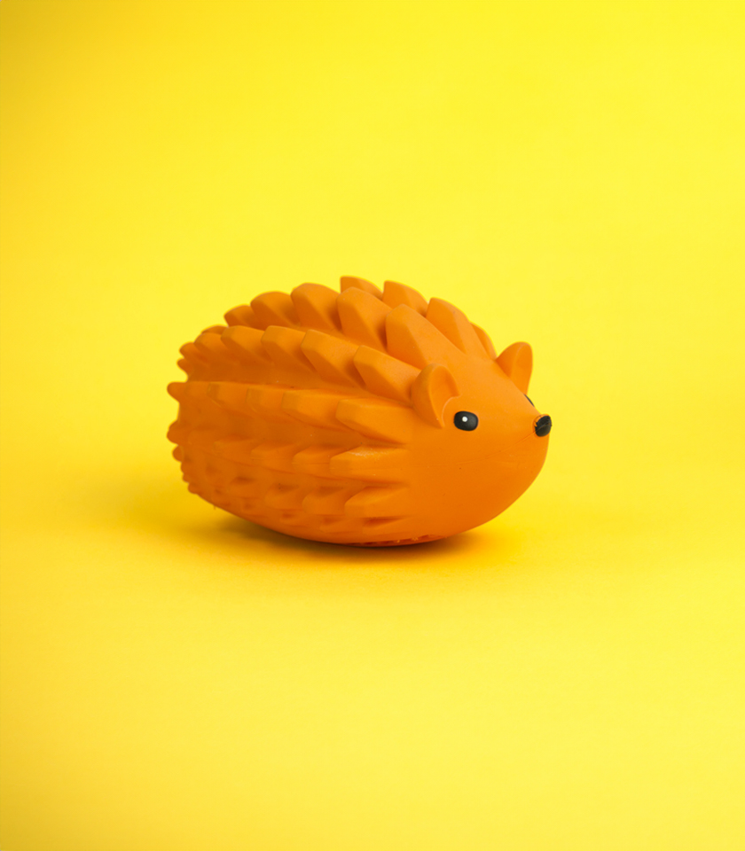 Zuhog Rubber Dog Toy, an orange toy shaped like a hedgehog with a spiky texture on its back.