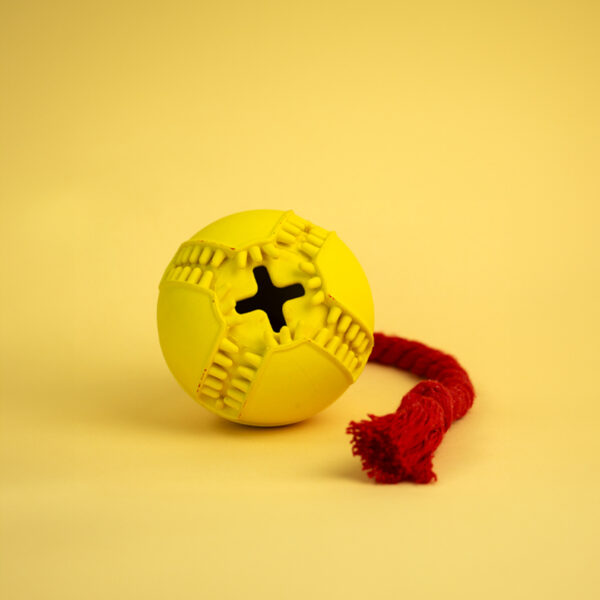 Tugball Rubber Dog Toy, a yellow ball with a textured surface, a cross-shaped hole, and a knotted red rope.